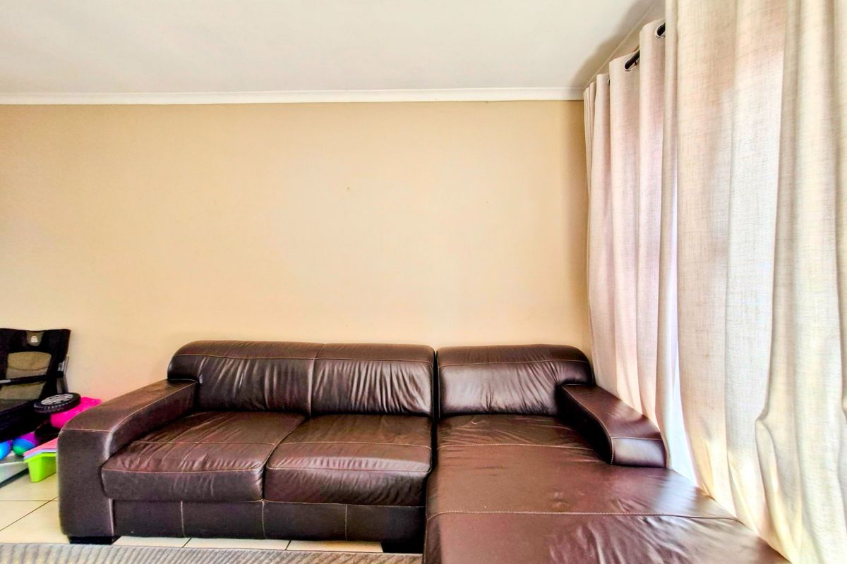 A living room area featuring tiled flooring and window curtain tracks, providing a neutral base for interior design.