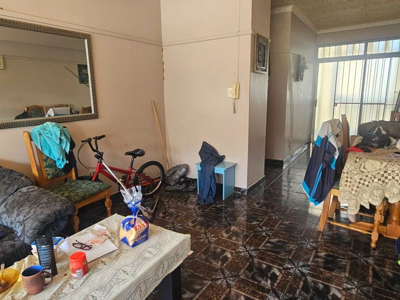 Open plan living and dining area featuring tiled flooring and access to a balcony through a sliding glass door.