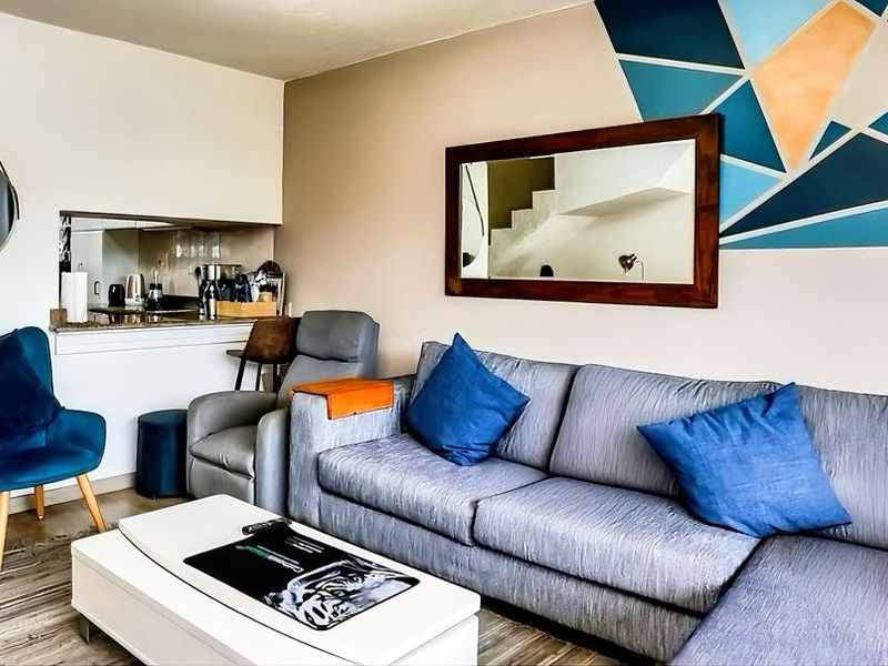 Open plan living area featuring laminate flooring and a convenient kitchen pass-through window with granite countertop.