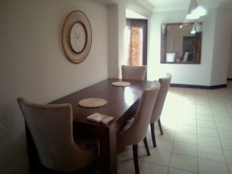 A dining area featuring tiled flooring and an internal window, providing a functional space for meals.