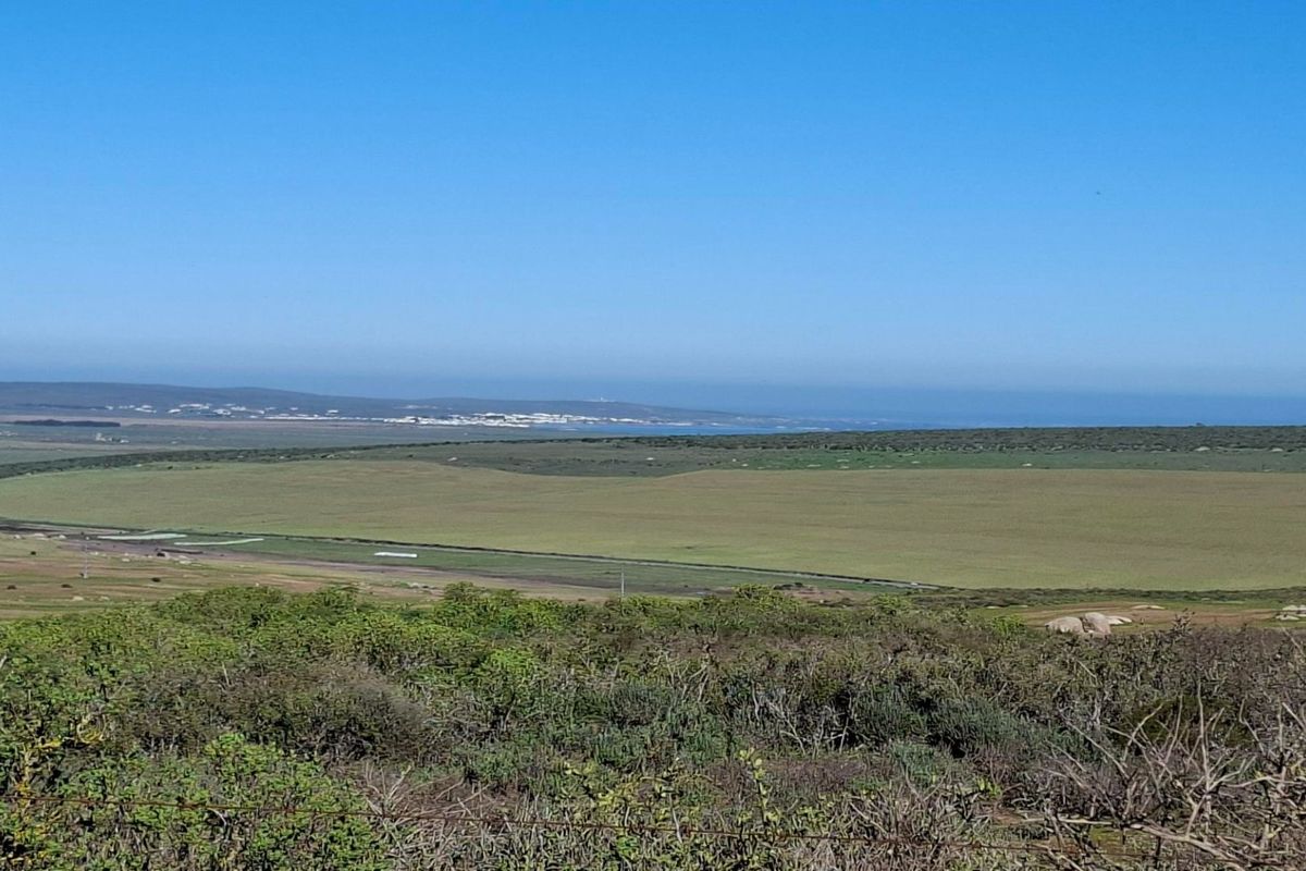 A wide-angle view of the expansive landscape, featuring natural vegetation and distant coastal scenery.