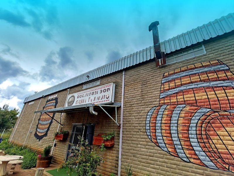 Front exterior view of a commercial building featuring brick masonry, a metal roof, and decorative wall murals.