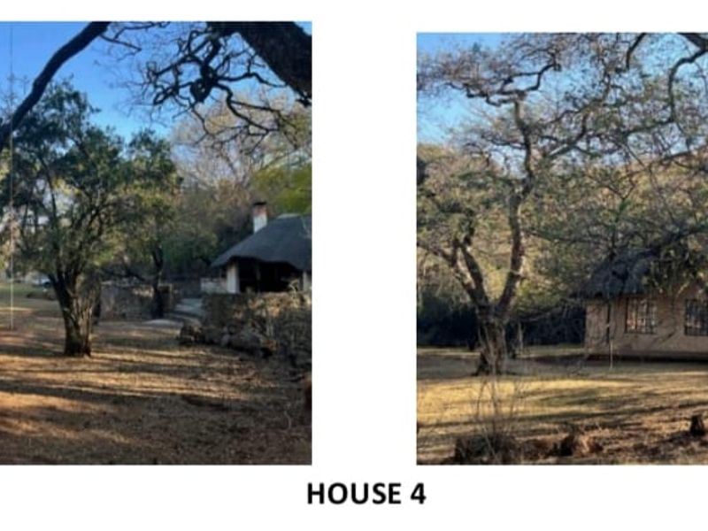 Exterior view of a rustic farm house featuring a traditional thatch roof, masonry construction, and a surrounding natural wooded garden area.