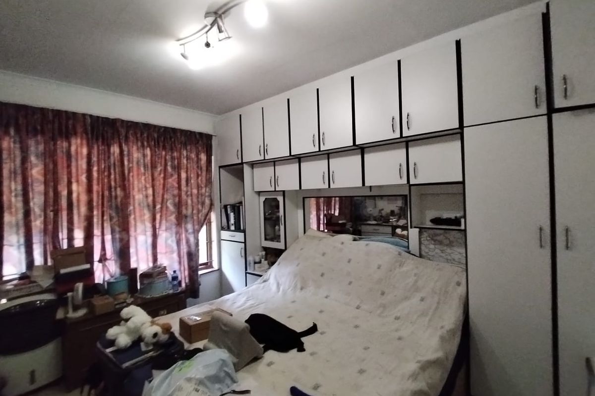 A bedroom featuring extensive built-in cabinetry and overhead storage units, providing ample storage space.