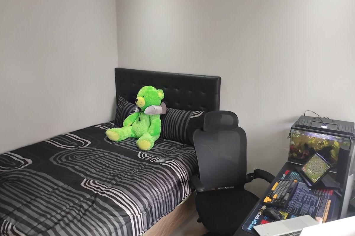 A compact bedroom featuring neutral wall finishes, suitable for use as a guest room or home office space.