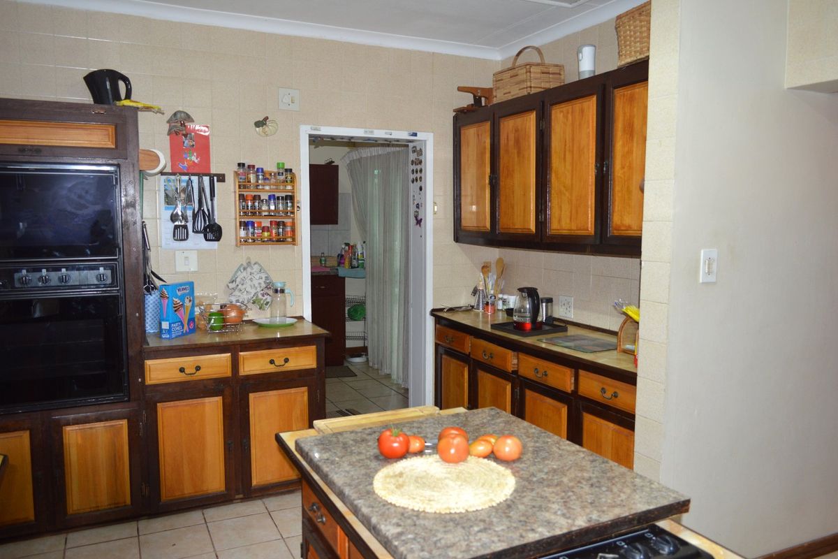 A functional kitchen featuring traditional two-tone wooden cabinetry, a double wall oven, and tiled backsplash, offering a classic layout with potential for modern updates.