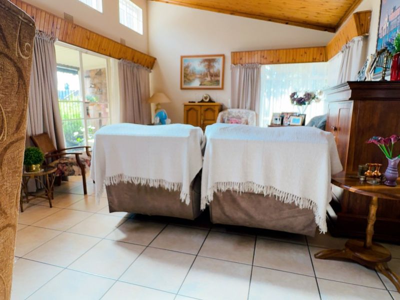 Spacious living room featuring tiled flooring, a high timber raked ceiling, and large sliding glass doors that provide ample natural light.
