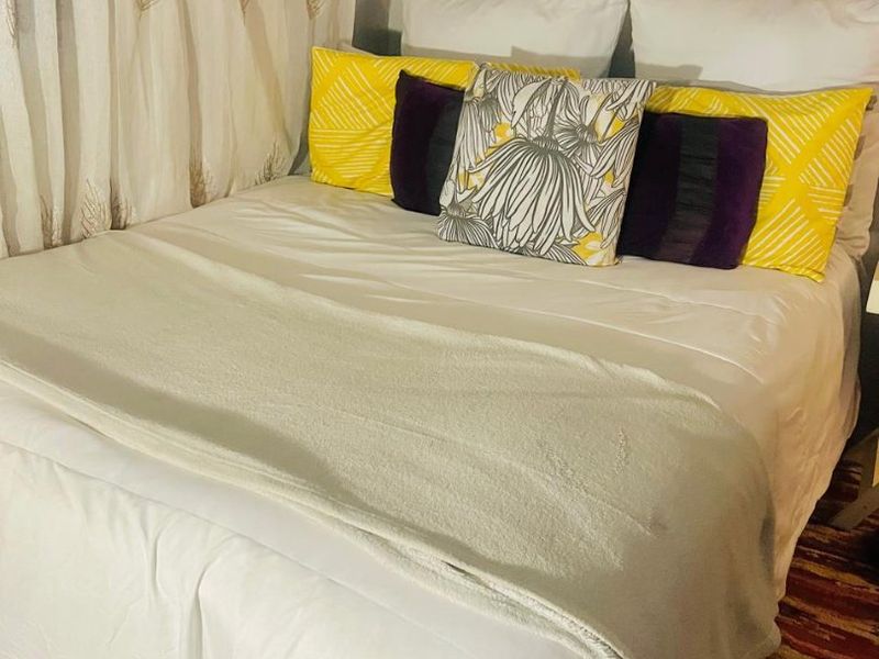 A bedroom space featuring tiled flooring and neutral wall finishes.