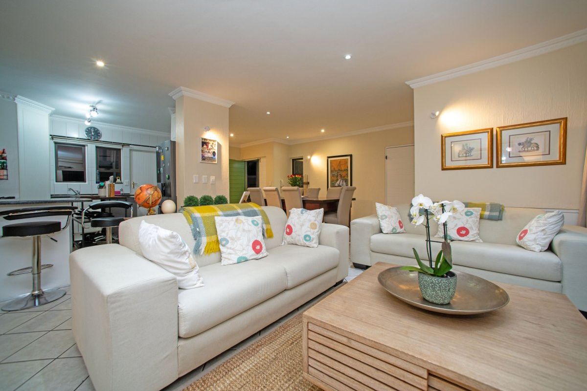 Spacious open-plan living area featuring a combined lounge, dining space, and kitchen with tiled flooring and recessed lighting.