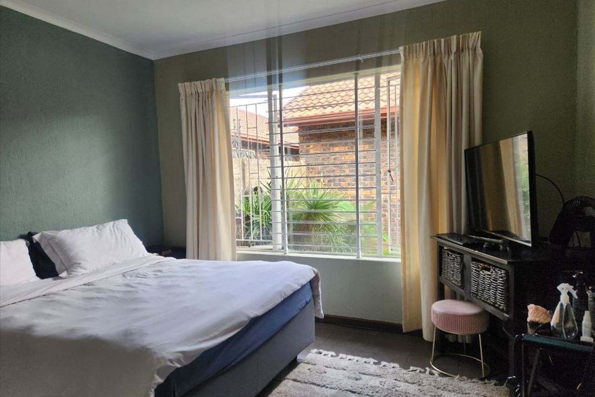 A bedroom featuring a window with security bars, coving, and skirting boards, providing a functional space with natural light.