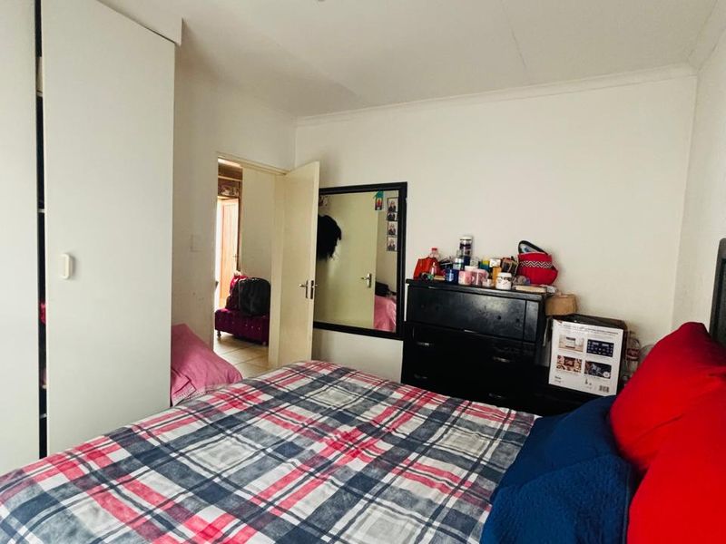 A standard bedroom featuring a built-in wardrobe and coved ceiling, providing a functional living space.
