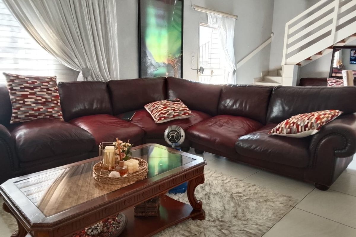 A comfortable living room featuring tiled flooring and an integrated staircase, providing a functional and open layout for relaxation.