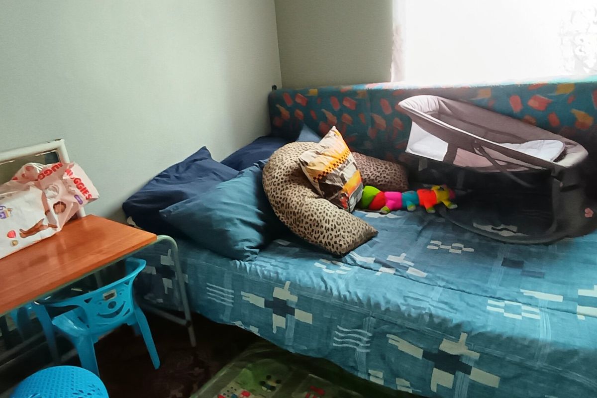 A bedroom space featuring a single bed and window, currently utilized as a nursery area.