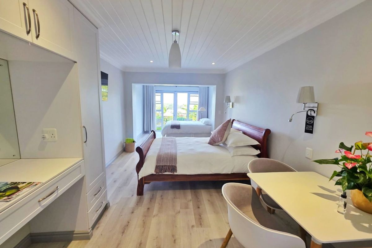 Spacious bedroom featuring light wood-look laminate flooring, built-in cabinetry, and a tongue and groove ceiling, with direct access to an outdoor balcony area.