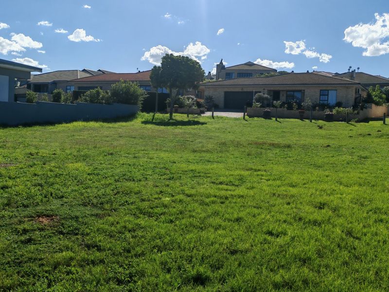 A vacant residential plot featuring a level grass lawn, offering a clear space for potential development in a established neighborhood.