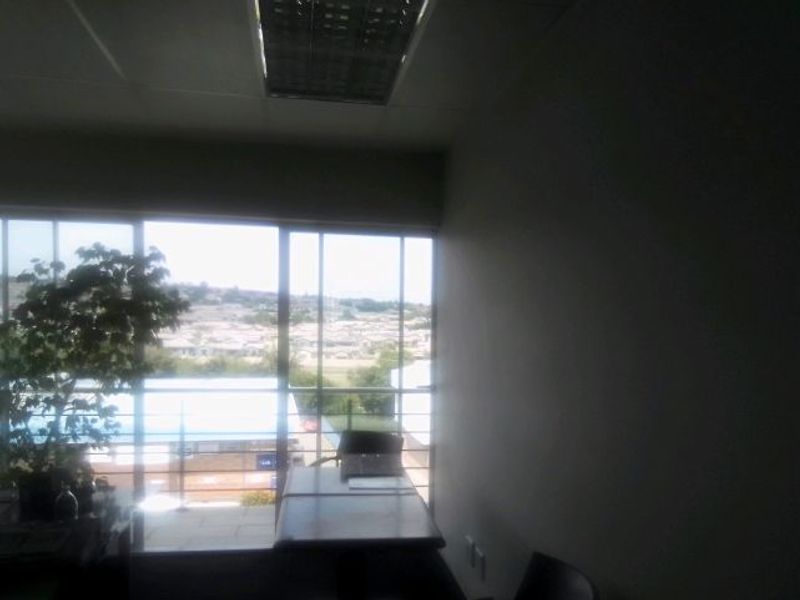 A commercial office space featuring large glass sliding doors that provide natural light and views of the surrounding area.