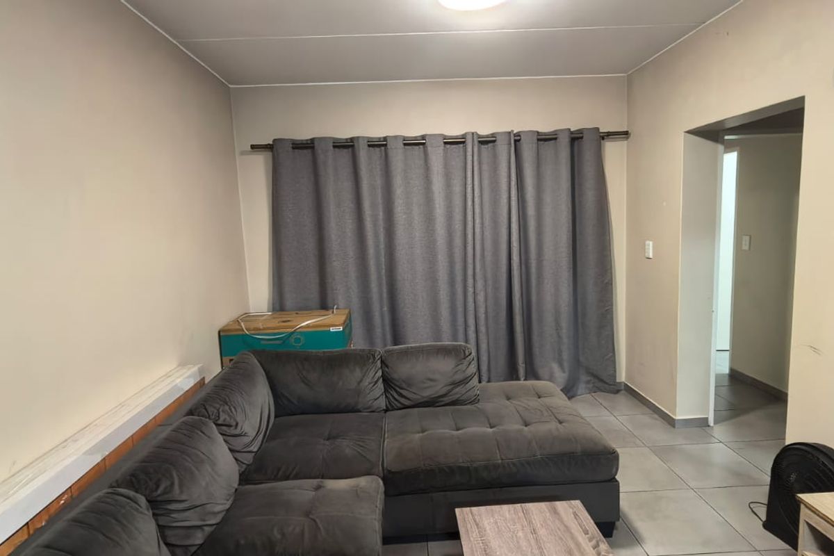 A living room featuring tiled flooring and neutral wall finishes, providing a functional space for relaxation.