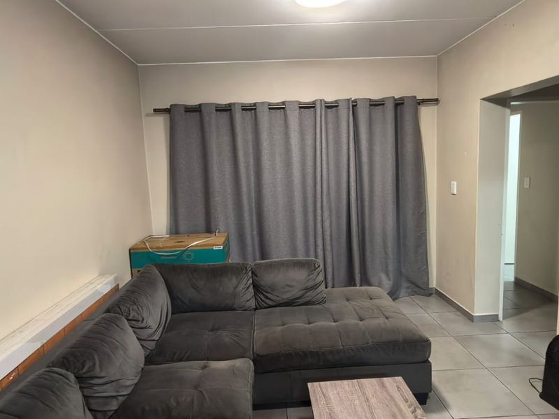 A living room featuring tiled flooring and neutral wall finishes, providing a functional space for relaxation.