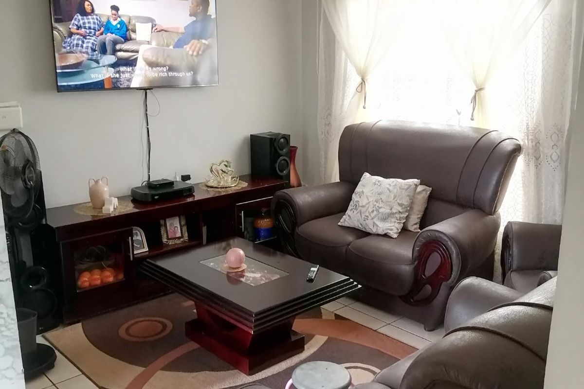 A functional living room featuring tiled flooring and neutral wall finishes, providing a comfortable space for relaxation.