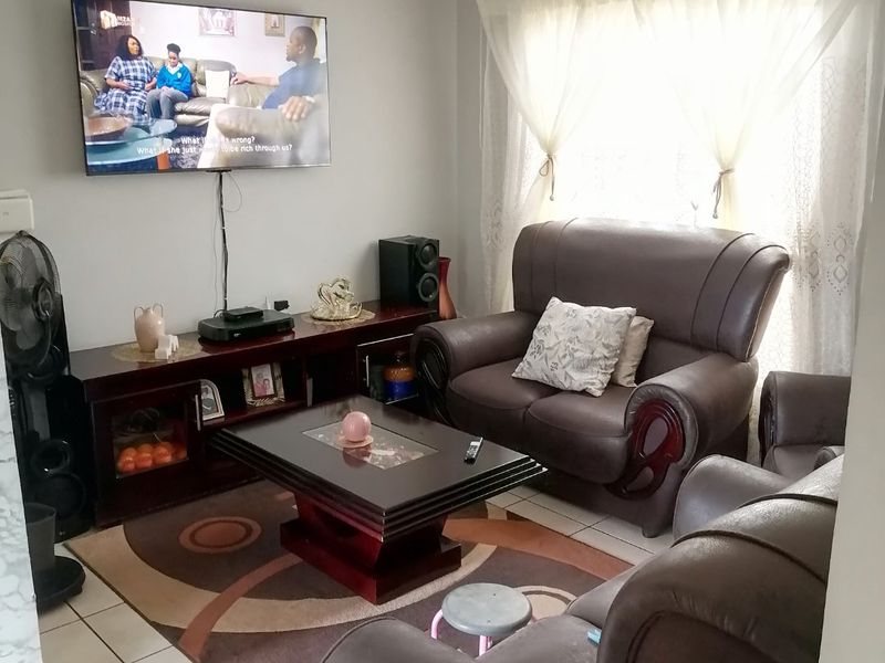 A functional living room featuring tiled flooring and neutral wall finishes, providing a comfortable space for relaxation.