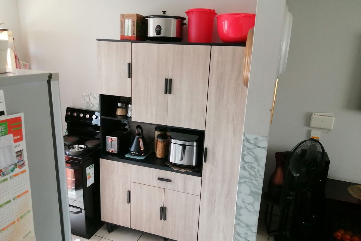 A kitchen area featuring a freestanding stove and modern wood-look cabinetry providing ample storage space.