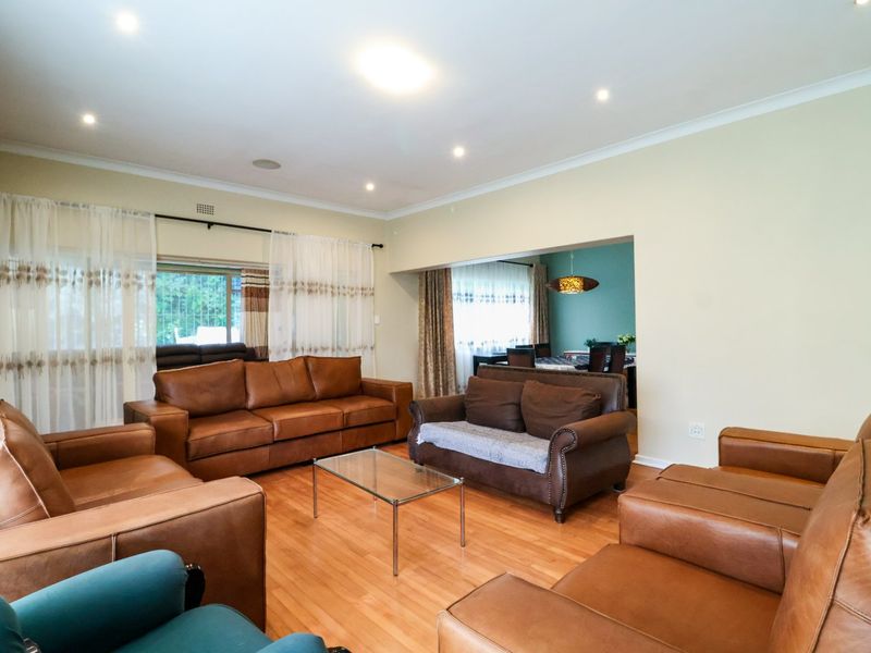 Spacious living room featuring laminate flooring, recessed downlighting, and a large sliding glass door providing access to the exterior.