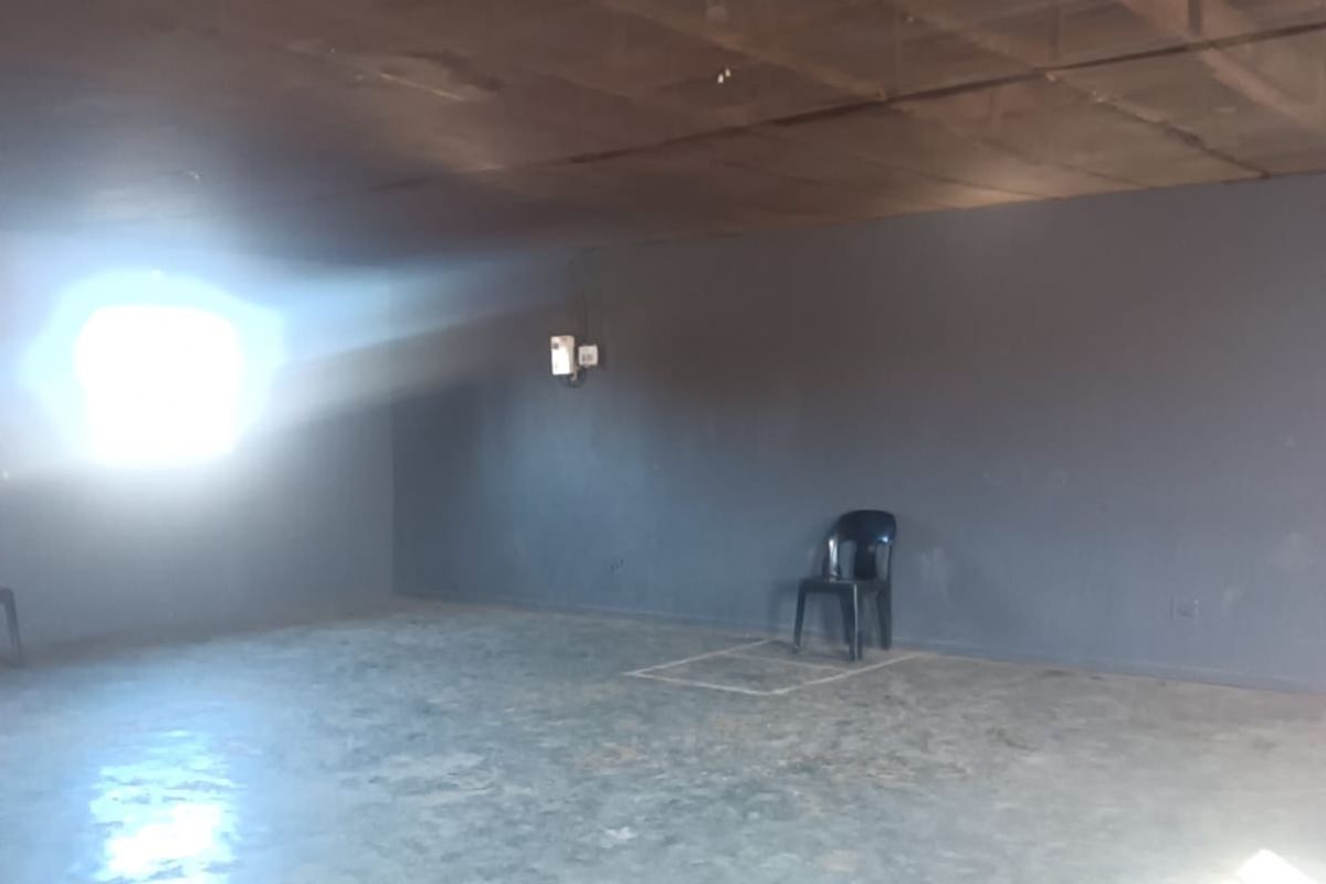 An open-plan interior space featuring exposed timber ceiling beams and concrete flooring, currently in a shell-like condition requiring renovation.
