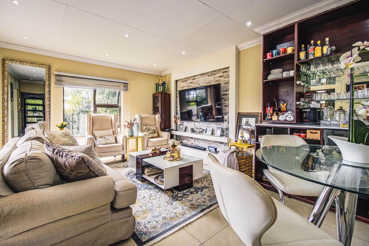A well-maintained living room featuring a stone accent wall, built-in shelving, recessed lighting, and tiled flooring, creating a comfortable and functional living space.