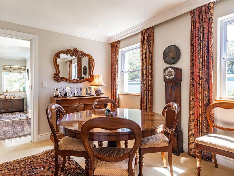 A well-maintained dining room featuring crown molding, recessed lighting, and large sash windows that provide ample natural light.