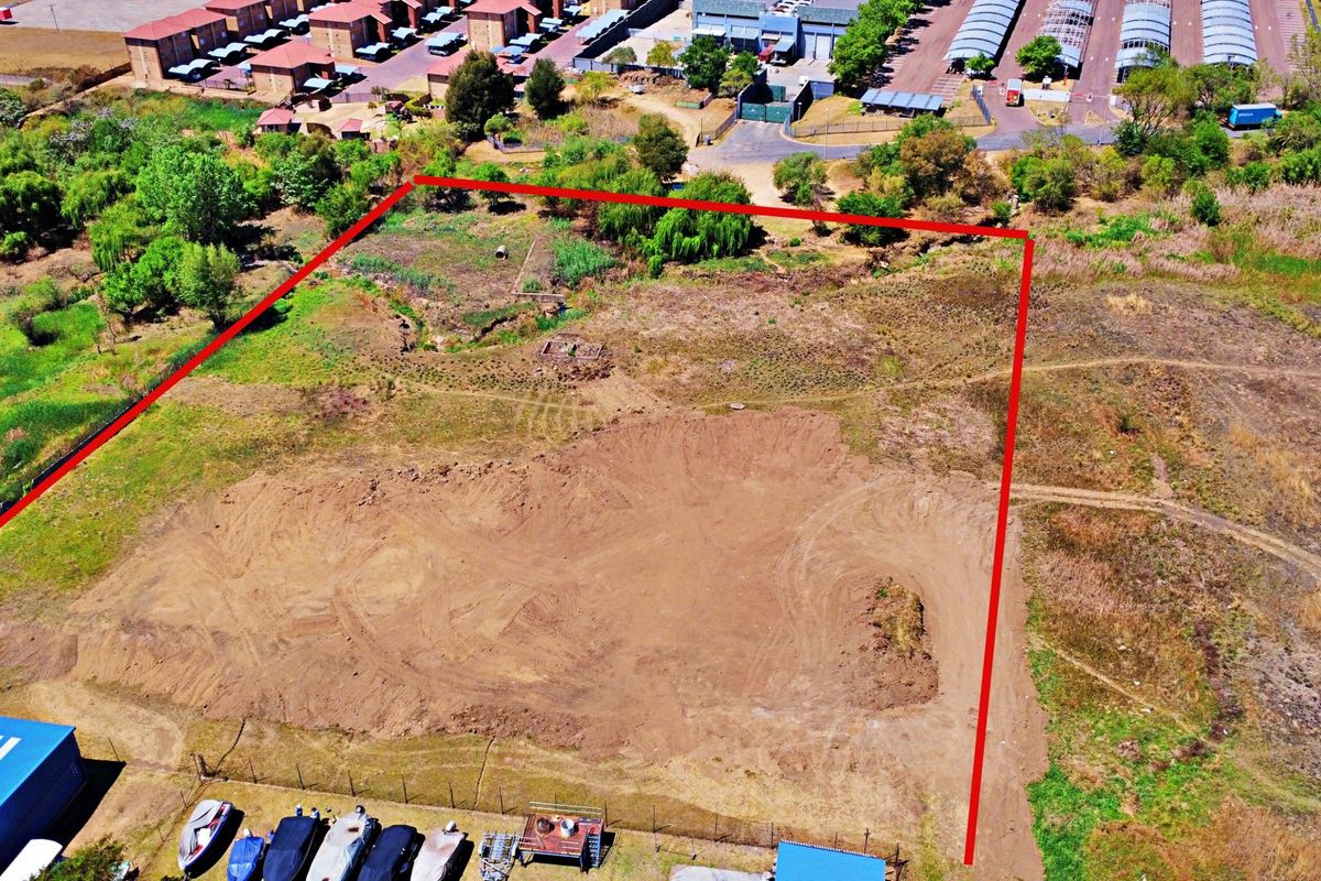 An aerial view of a vacant residential plot with cleared ground, showing the property boundaries and surrounding neighborhood context.