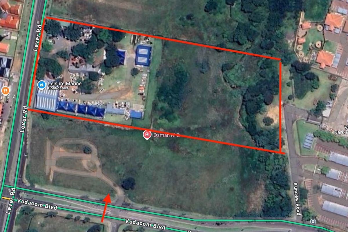An aerial view of a vacant residential land parcel, showing surrounding road access and existing vegetation.