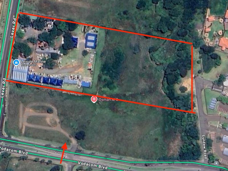 An aerial view of a vacant residential land parcel, showing surrounding road access and existing vegetation.