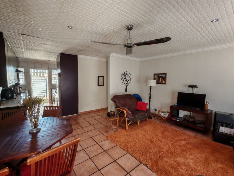Open plan living and dining area featuring tiled flooring, recessed lighting, and a ceiling fan, with an adjacent kitchen area.