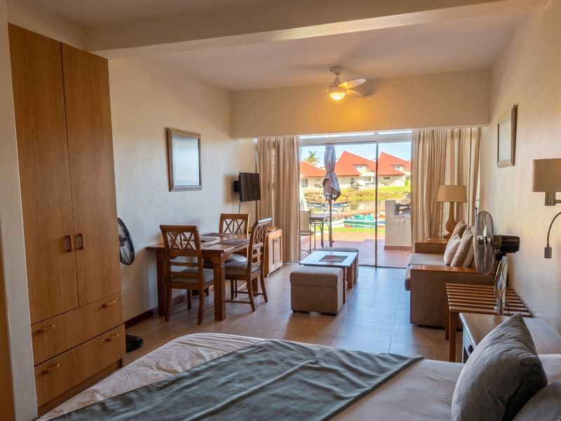 A bedroom featuring built-in cabinetry, tiled flooring, and a sliding glass door providing access to an outdoor patio area.