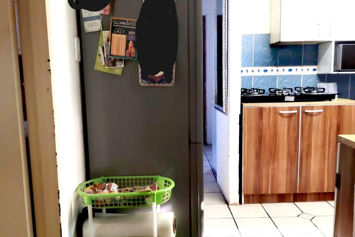 A functional kitchen area featuring built-in cabinetry, a gas hob, and tiled backsplash, offering a practical layout with potential for modern updates.