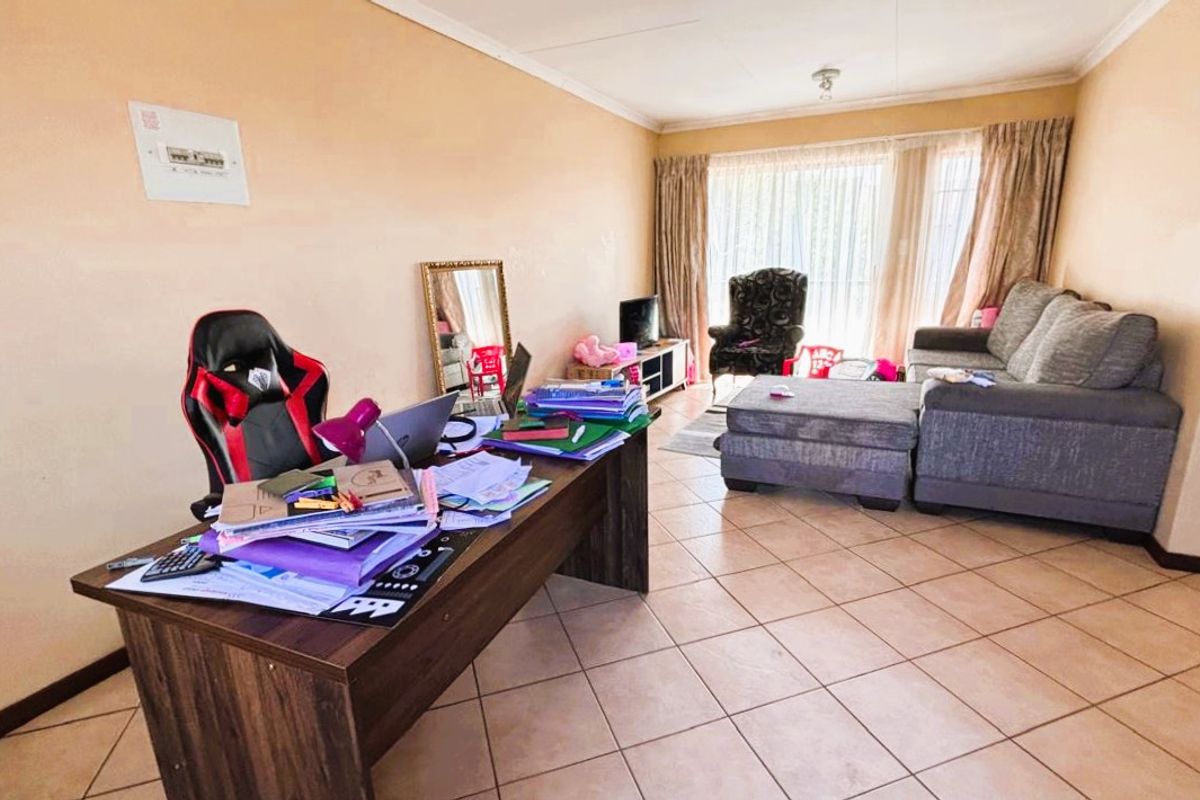 A spacious living area featuring tiled flooring and a large sliding glass door that provides natural light and access to the exterior.
