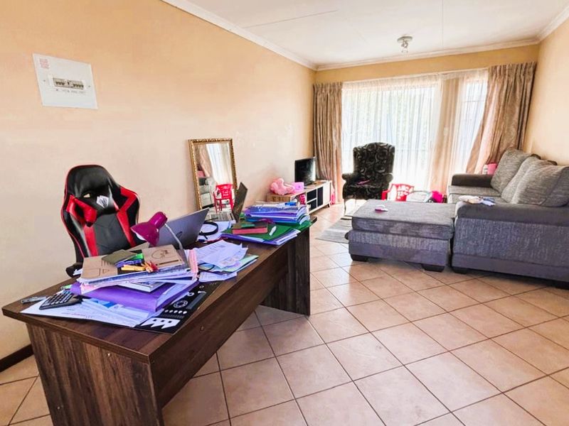 A spacious living area featuring tiled flooring and a large sliding glass door that provides natural light and access to the exterior.