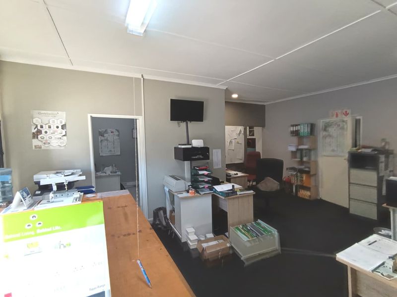 A functional commercial office space featuring neutral wall finishes, overhead fluorescent lighting, and integrated storage solutions.