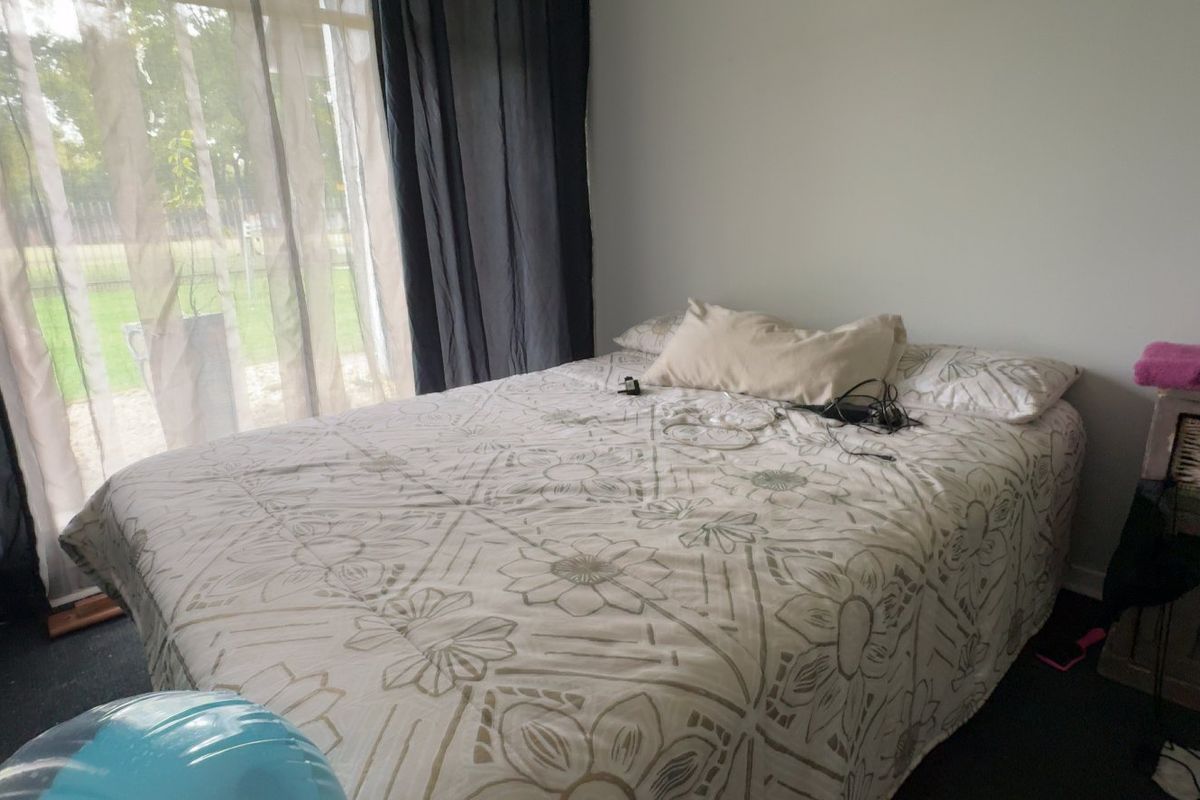A bedroom featuring a large sliding glass door providing natural light and access to the exterior.