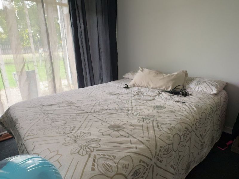 A bedroom featuring a large sliding glass door providing natural light and access to the exterior.