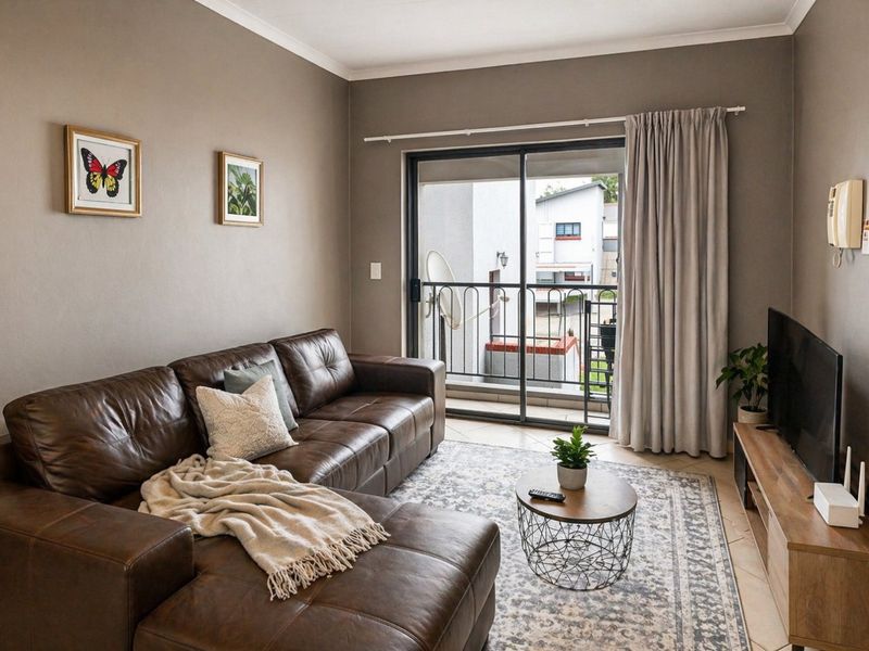 A well-maintained living room featuring tiled flooring and a sliding glass door that opens onto a balcony.