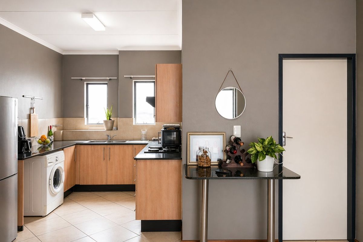 A functional kitchen featuring laminate cabinetry, granite countertops, tiled flooring, and a dedicated space for laundry appliances.