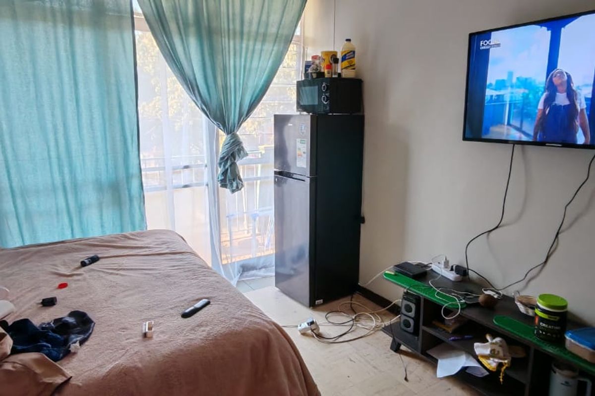 A bedroom featuring tiled flooring and a sliding glass door providing access to an outdoor area.