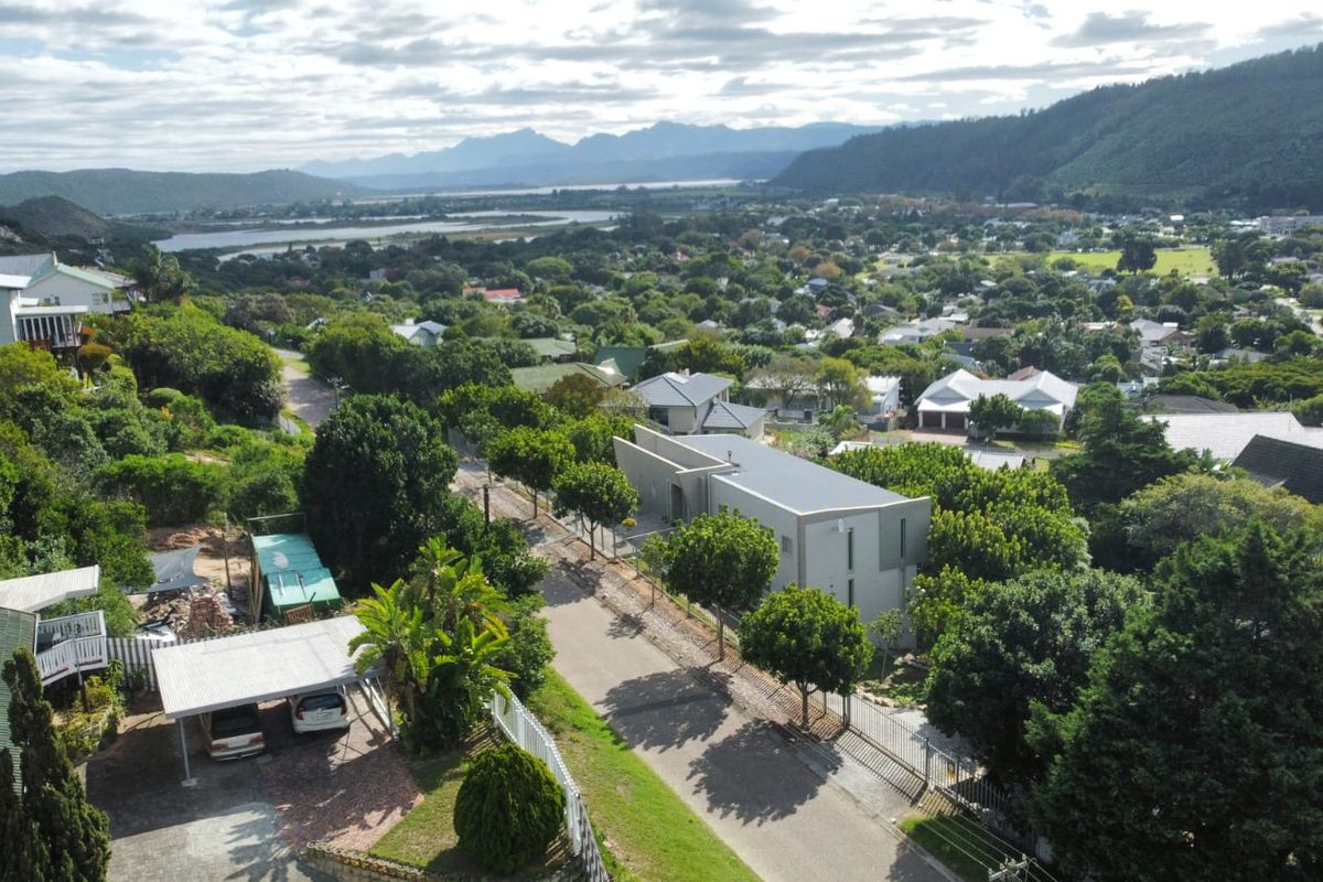Aerial view of the property showing the surrounding residential neighborhood, landscape, and mountain backdrop.