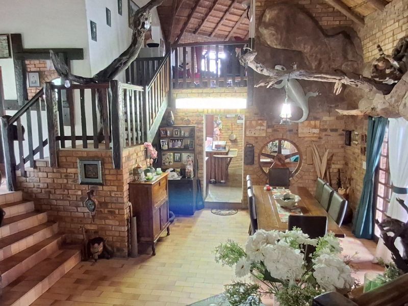 Spacious living area featuring rustic exposed brick walls, timber staircase, and mezzanine level, creating a unique character-filled interior space.