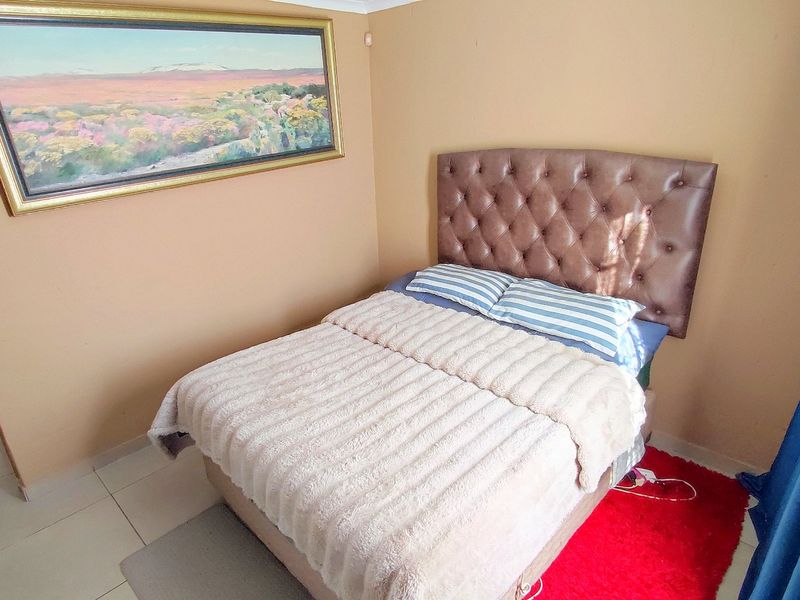 A standard bedroom featuring tiled flooring and neutral wall finishes, providing a functional space for rest.