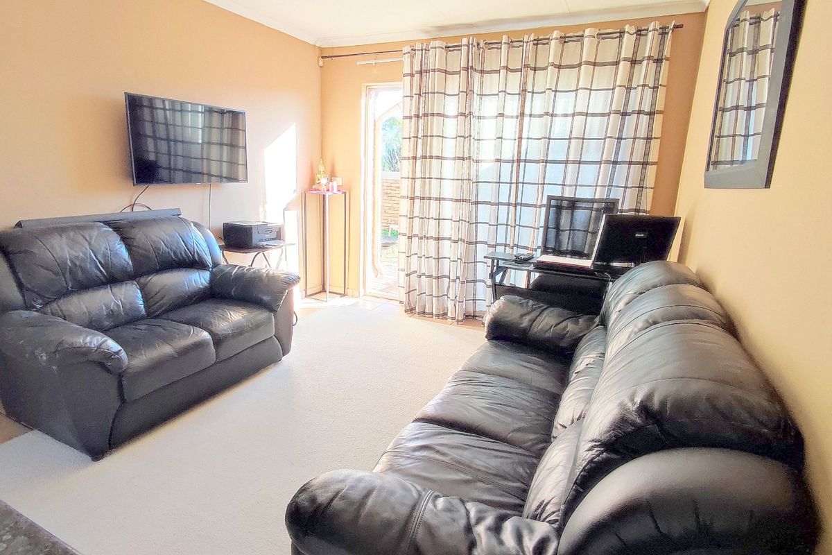 A living room featuring carpet flooring and a sliding glass door providing access to the exterior.