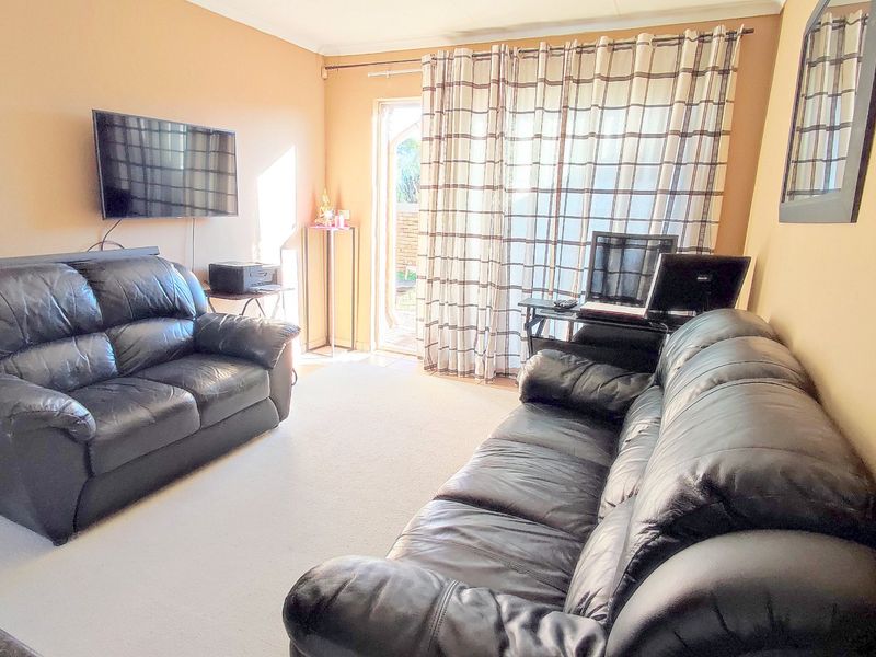 A living room featuring carpet flooring and a sliding glass door providing access to the exterior.
