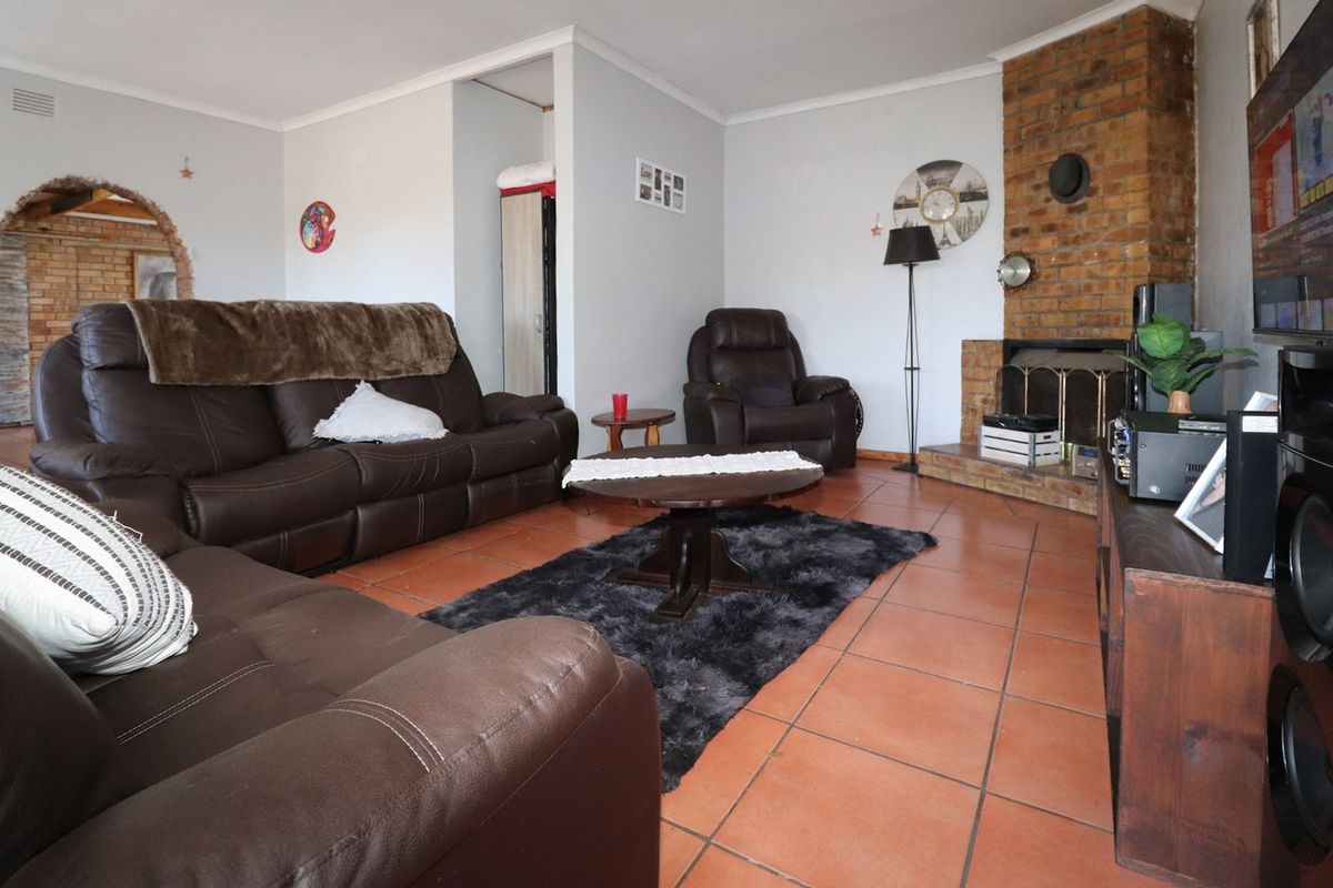 A living room featuring terracotta floor tiles and a prominent brick fireplace, offering a warm and traditional foundation for interior updates.