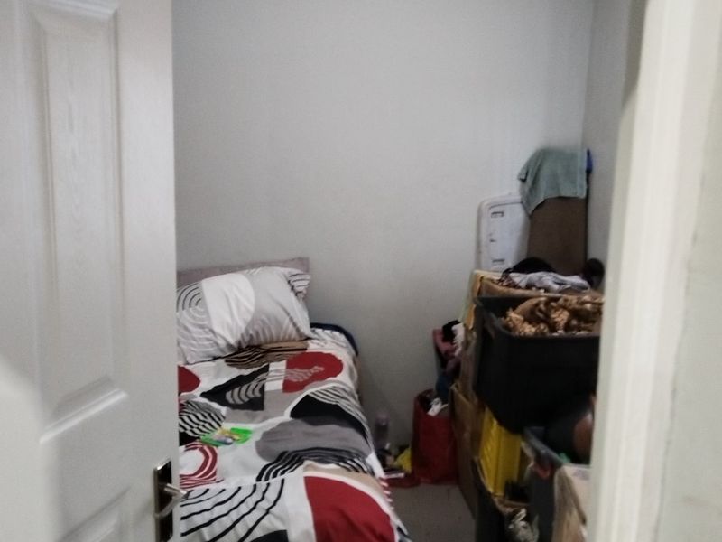 A compact bedroom space featuring a single bed and basic finishes, suitable for a small guest room or study.